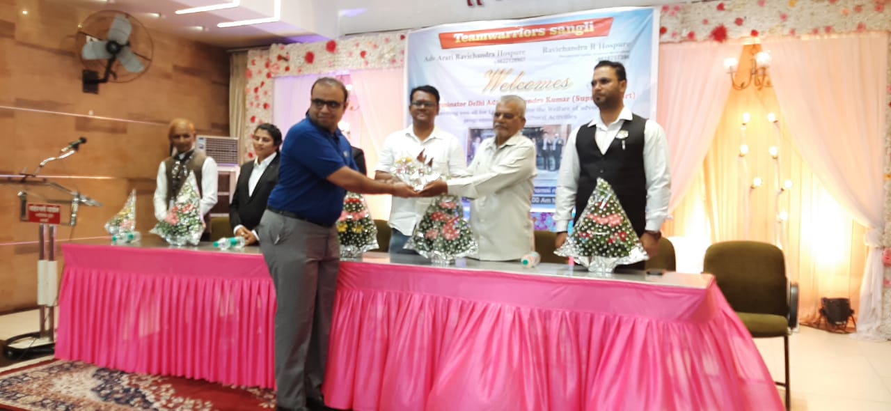 Guests receiving bouquets on a stage in front of a pink-draped table.